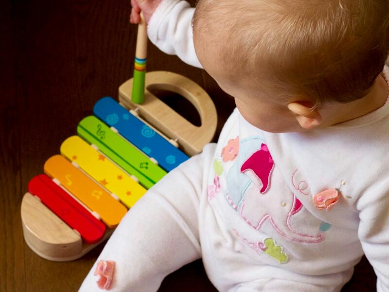 Un bebé juega con un xilófono de madera