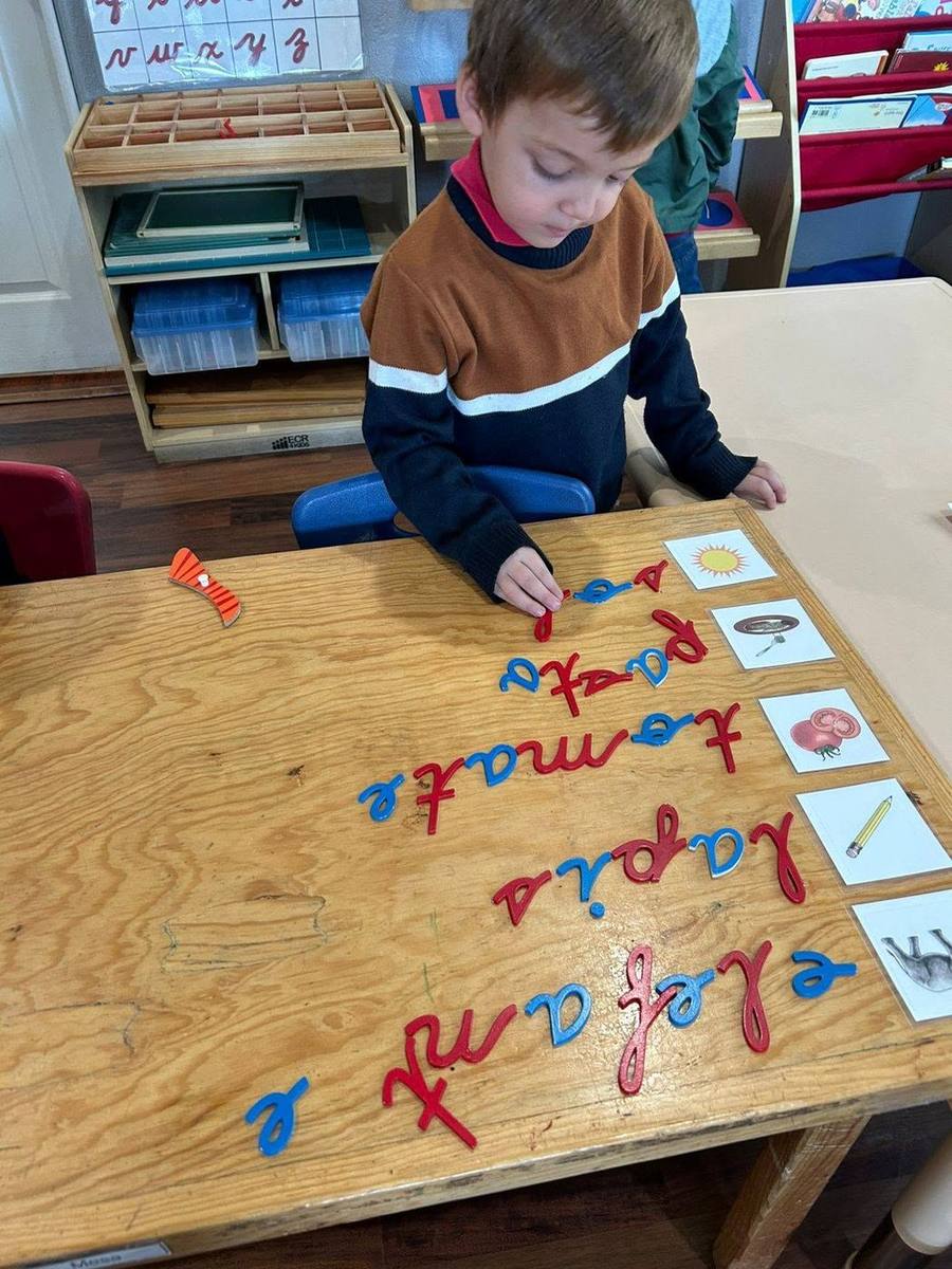 Un niño forma palabras en español con el alfabeto móvil