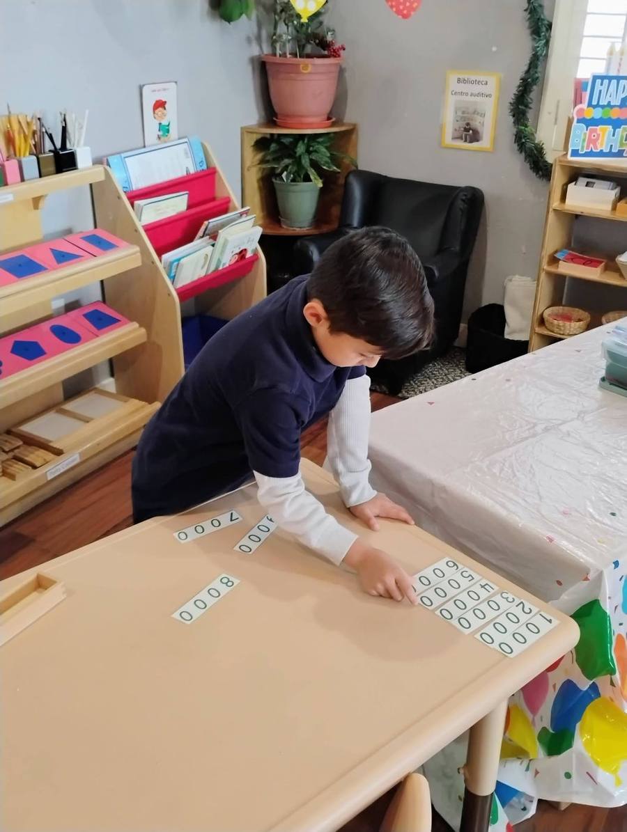 Un alumno de primaria acomoda tarjetas de números hasta los miles